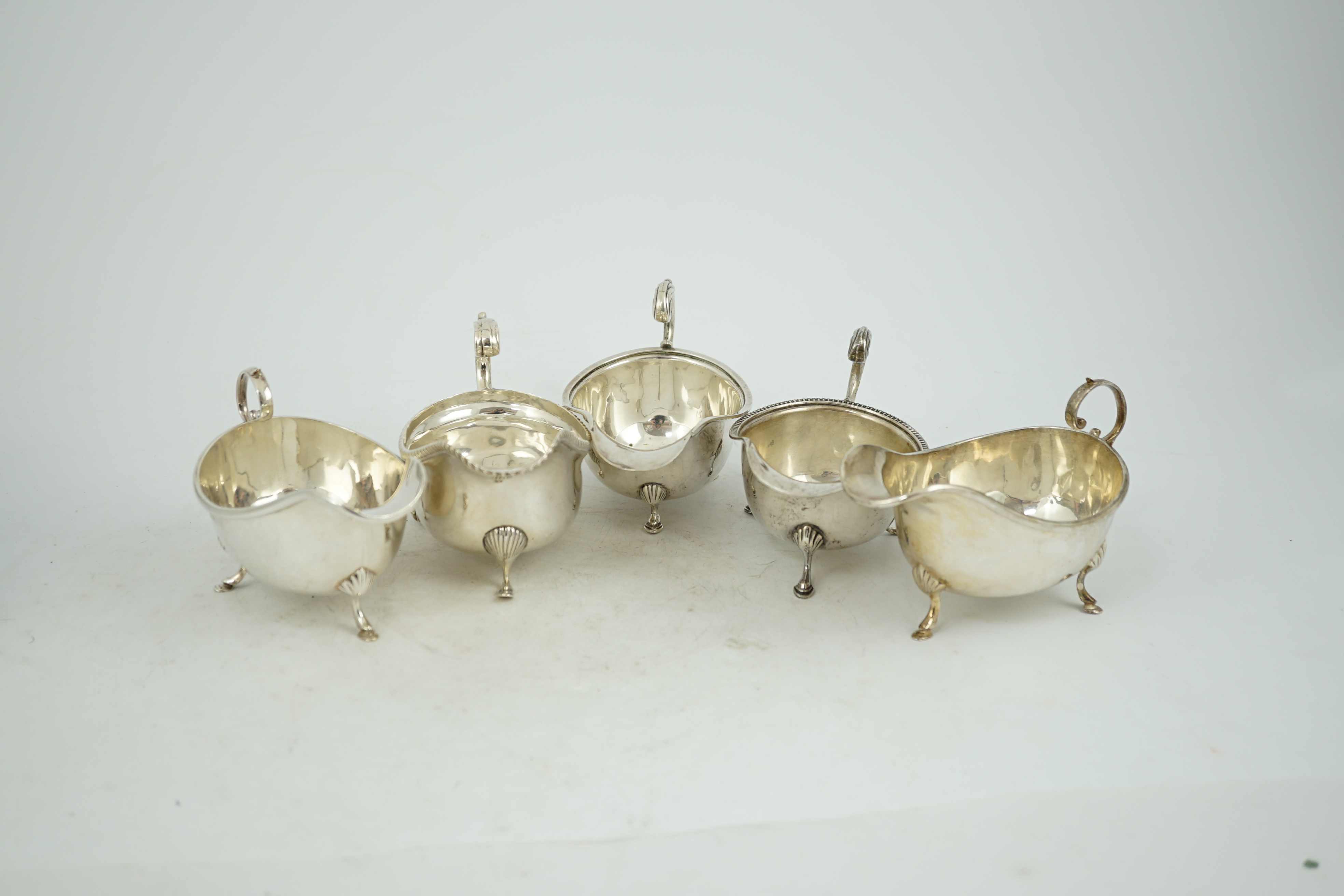 Five assorted early 20th century and later silver sauce boats, various dates and makers, 21.3oz.